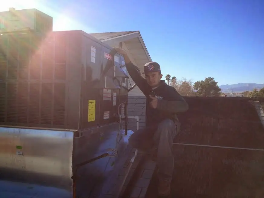 HVAC technician performing Heat Pump Repair on a rooftop unit in Highlands Ranch